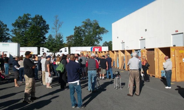 picture of people at a storage unit auction waiting for bidding to begin